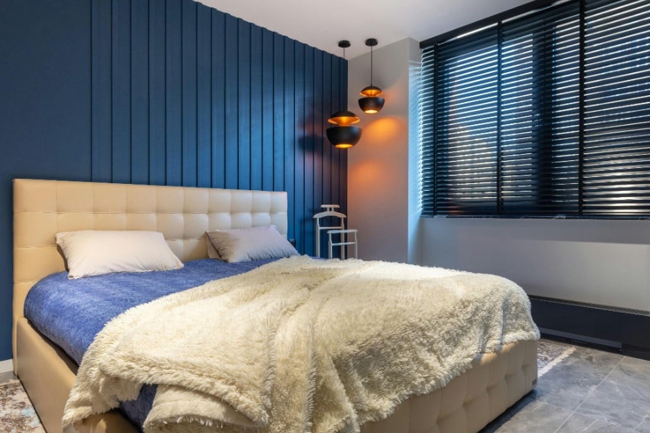 a woman peeping through a window blind