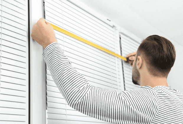 an engineer measuring window blind